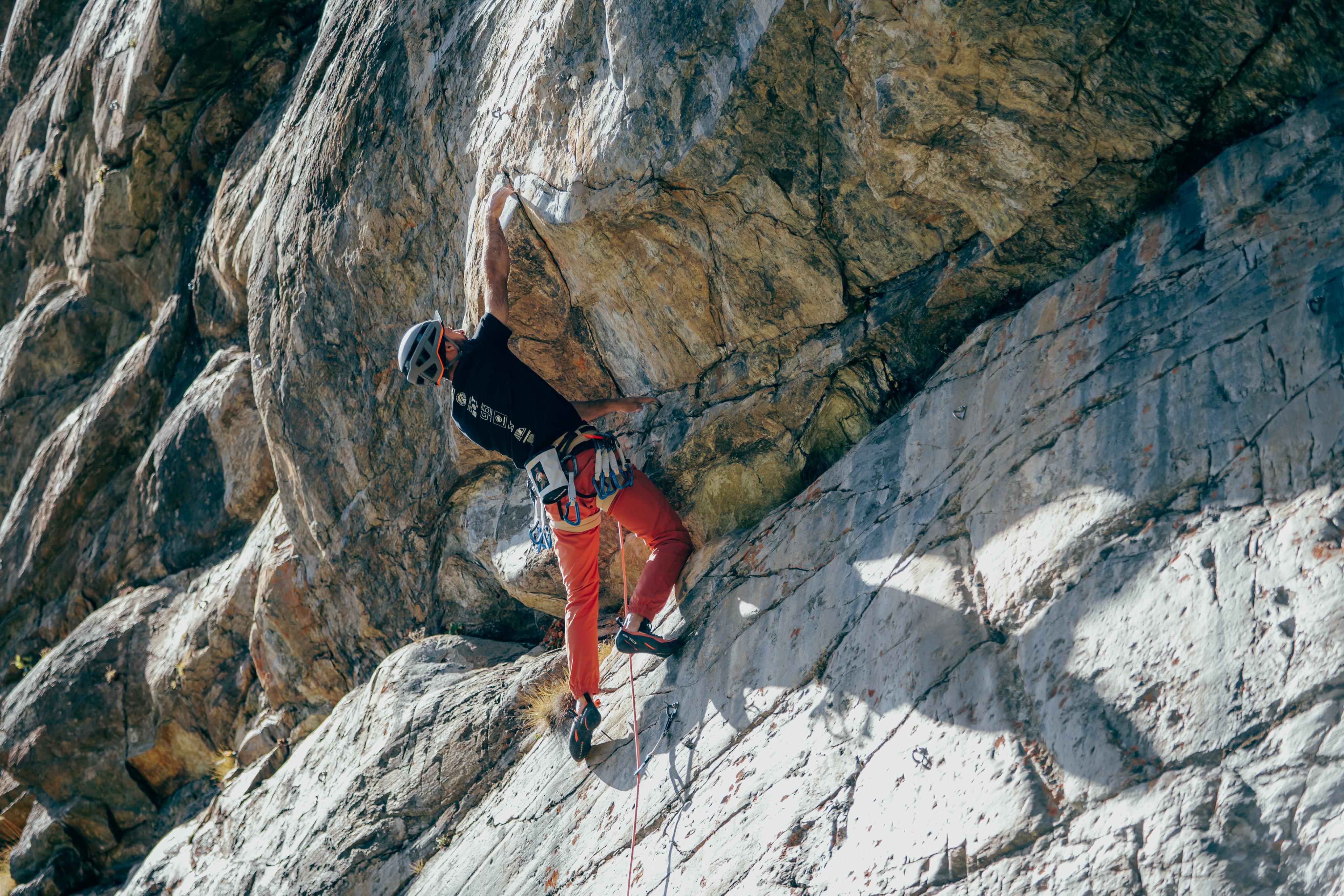 Person wearing Mammut protective gear rock climbing on a steep rock face.